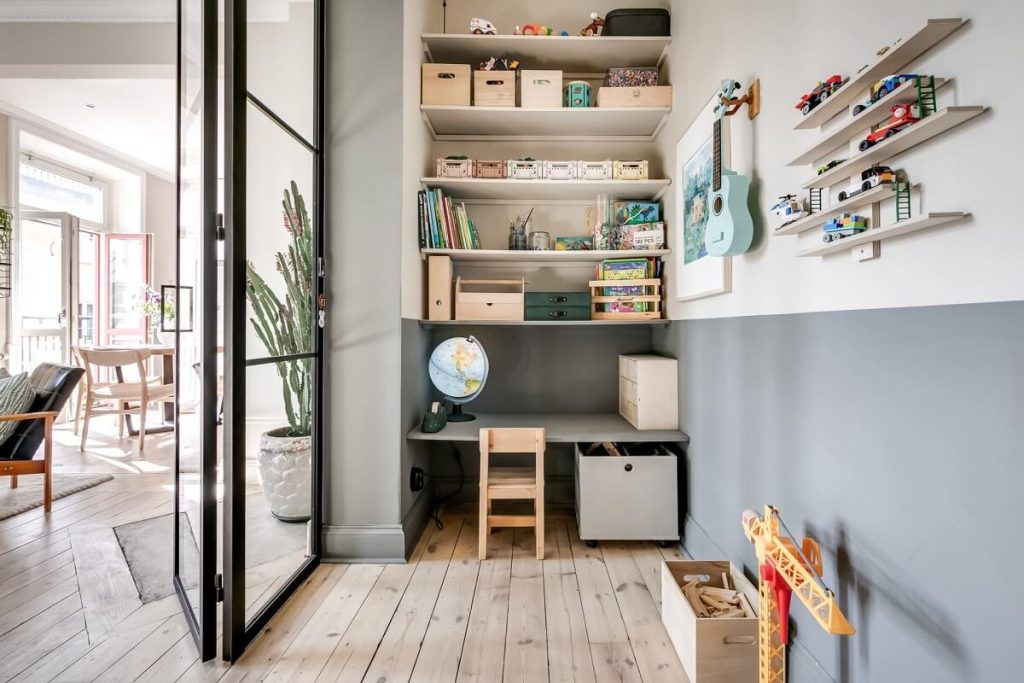 In deze leuke en speelse kinderkamer is de wandplank en het bureau in dezelfde kleur geschilderd als de muur. In deze leuke en speelse kinderkamer is de wandplank en het bureau in dezelfde kleur geschilderd als de muur.